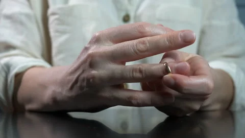 Lady takes off wedding ring with problems. 動画素材 276634189
