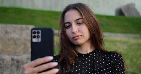 Lady taking selfportrait on park steps. Woman peacefully recording short social Stock-Footage 344720360