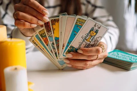 Lady tarot reader pulls a tarot card from the deck Stock Photos