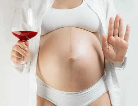 Lady in the third trimester of pregnancy informs that you should not drink Stock Photos