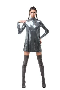 Lady thoughtfully looking in camera wearing dress in sequins and knee high boots Stock Photos