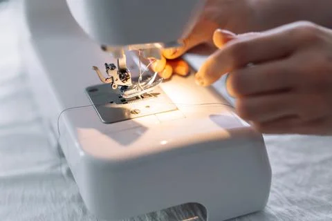 Lady threading a sewing machine needle Stock Photos