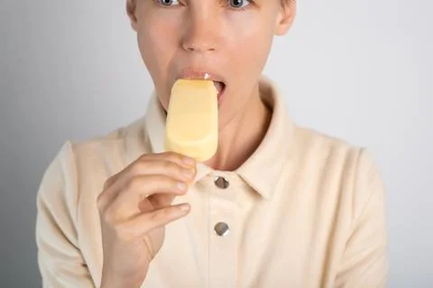 A lady with a trendy pixie cut indulges in ice cream, savoring the sweetnes.. Stock Photos