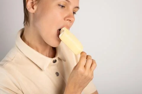 A lady with a trendy pixie cut indulges in ice cream, savoring the sweetness  Stock Photos