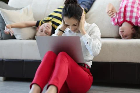 Lady try to concentrate on work while kids go nuts at home on quarantine Stock Photos