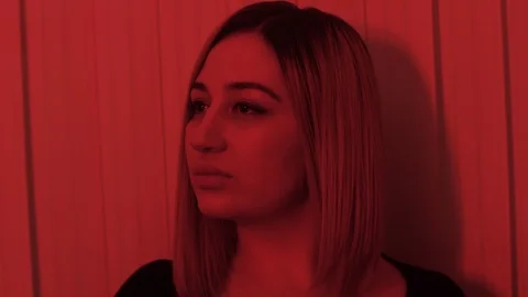 Lady turns head under red light slow motion close view Stock Footage 105250013