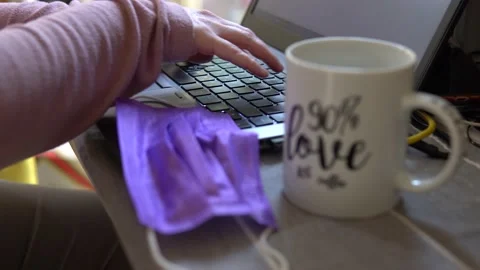 Lady types on laptop at home  with face mask  nearby  Stock Footage 145965041
