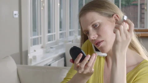 Lady uses mobile Phone while applying make up Stock Footage 63032655