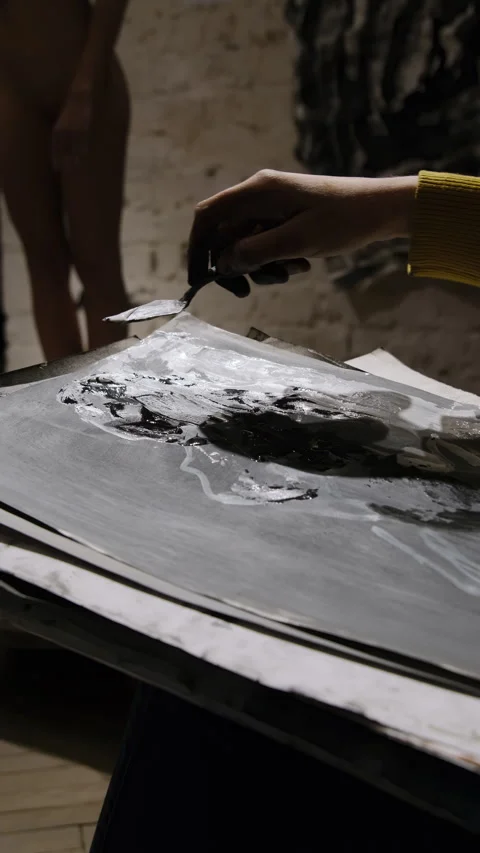 Lady uses special tool to spread paint over sheet surface Stock Footage 306458097