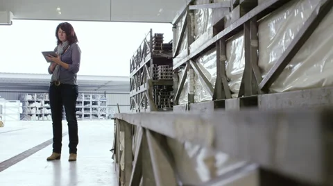 Lady uses Tablet while standing in factory Stock Footage 63029030