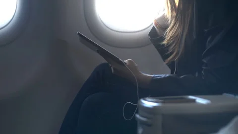 Lady using her modern tablet in airplane Stock Footage 103948970