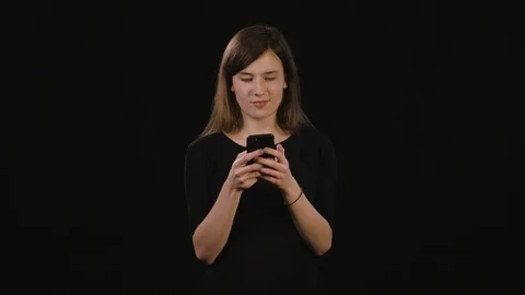 A Lady Using a Phone Against a Black Background Stock Footage 87167439