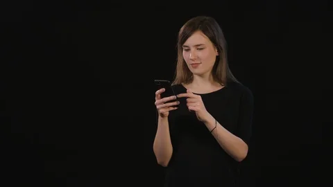 A Lady Using a Phone Against a Black Background Stock Footage 87167701