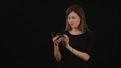 A Lady Using a Phone Against a Black Background Stock Footage 87168435