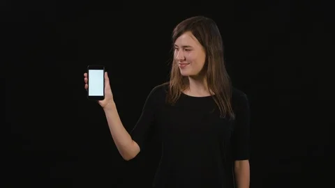 A Lady Using a Phone Against a Black Background Stock Footage 87172488