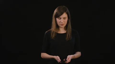 A Lady Using a Phone Against a Black Background Stock Footage 87172730