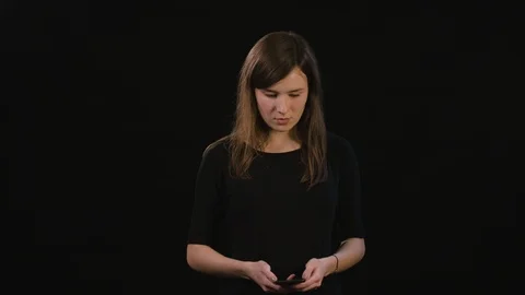 A Lady Using a Phone Against a Black Background Stock Footage 87173067