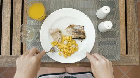 Lady is using utensils to cut meal in small bites Video stock 65558130