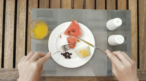 Lady is using utensils to cut meal in small bites Stock Footage 65558534