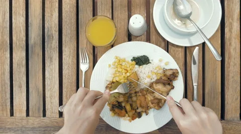 Lady is using utensils to cut meal in small bites Stock Footage 65560480