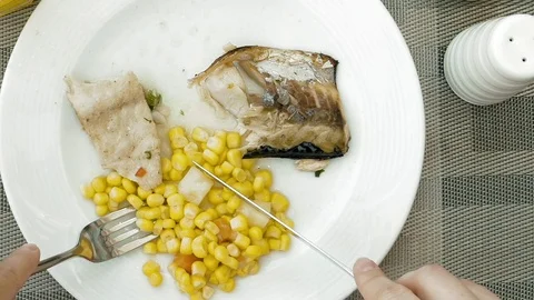 Lady is using utensils to cut meal in small bites Stock Footage 70000604