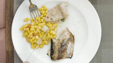 Lady is using utensils to cut meal in small bites Stock Footage 91183526