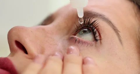 Lady with vision problems drips special drops onto eyeball Stock Footage 261028323