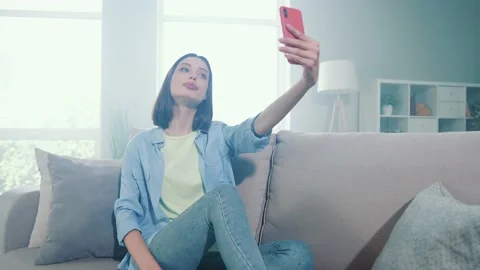Lady vlogger sit divan make selfie smart device in modern apartment Stock Footage 166216842