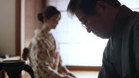 Lady waits while tea master prepares a bowl of tea during ceremony in a traditio Stock Footage 199462901
