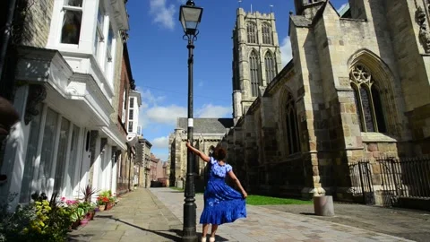 Lady walking by Howden Minster in summertime Yorkshire United Kingdom Stock Footage 205601425