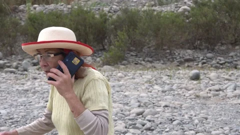 A lady walking talking on the phone through dry rivers  Stock Footage 141931066