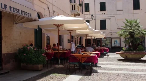 A lady walks between restaurant in an old town square Stock Footage 62151890