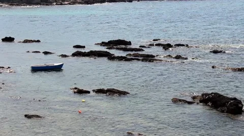 A lady walks between rocks in the Mediterranean sea Stock Footage 62400093