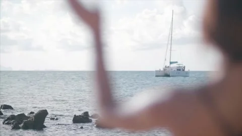 Lady waves at Catamaran from the shore., close up. Stock Footage 159723148