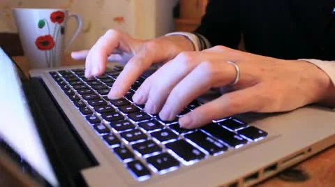 Lady with a wedding ring typing on a notebook Stock Footage 12377998