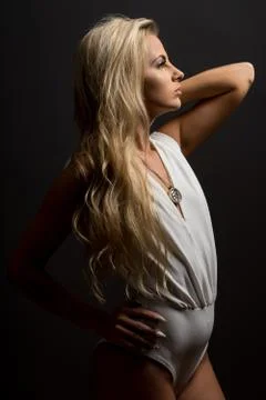 Lady in white blouse posing in studio. Beautiful elegant woman, long blond ha Stock Photos