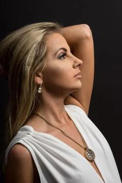 Lady in white blouse posing in studio. Beautiful elegant woman, long blond ha Stock Photos