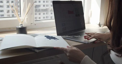 Lady working with computer, writing information in personal organizer Video stock 127849725