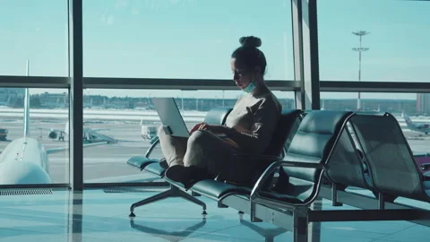 A lady is working on her laptop while waiting for her flight Video stock 152618116