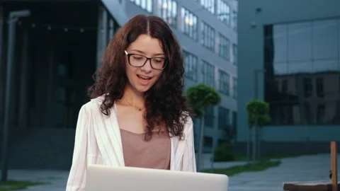 Lady working on laptop computer sitting at bench outdoor. Success happy pose. Stock-Footage 160540873
