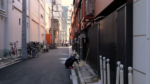 A lady working on the side of the narrow street in Tokyo Japan Stock Footage 121378705