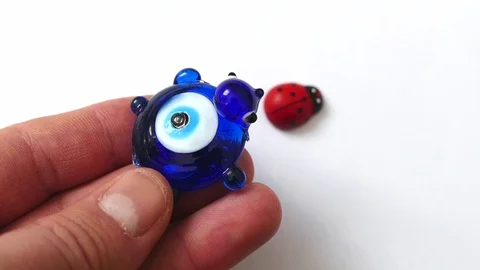 Ladybug and evil eye bead on a white background, Stock Footage 124788695