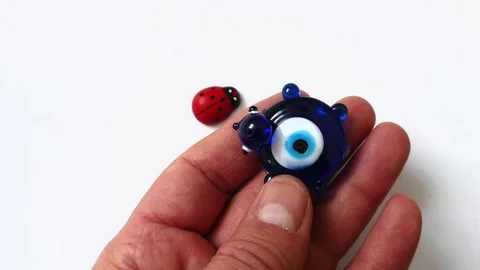 Ladybug and evil eye bead on a white background, Stock Footage 124788944