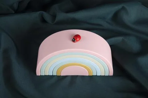 A ladybug resting on a plastic rainbow toy Stock Photos