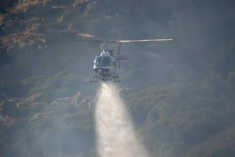 A LAFD Bell 206 helicopter makes a water drop on a brush fire in Chatsworth, Foto stock