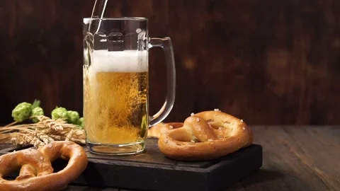 Lager beer is pouring into a mug. Light beer on a wooden table. Stock Footage 115564630