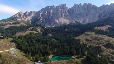 Lago di Carezza Bathed in Intense Yellow Light, With Golden Reflections Across Stock Footage 345671429