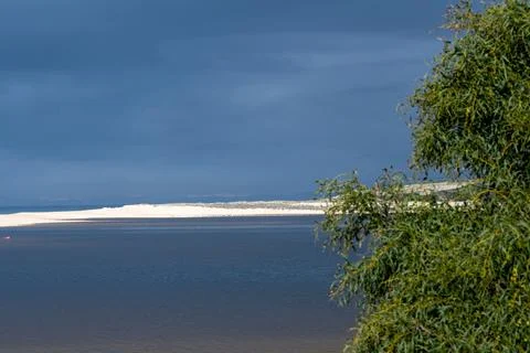 Lagoon and sandbar under dramatic storm clouds Stock Photos