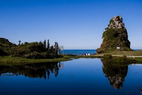 Lagoon Reflection with Ocean View and Rock Formation Stock Photos