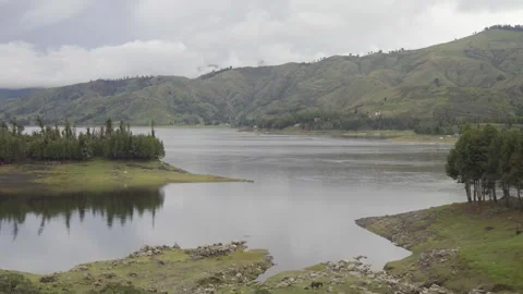 Lagoon surrounded by mountains and a pine forest, Andean mountains, Lake Corani Stock Footage 277468742